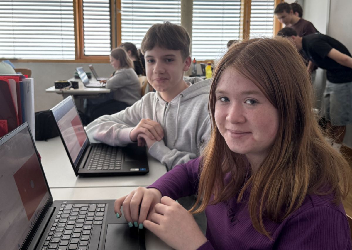 Schülerin lächelt am Laptop beim Programmier-Workshop
