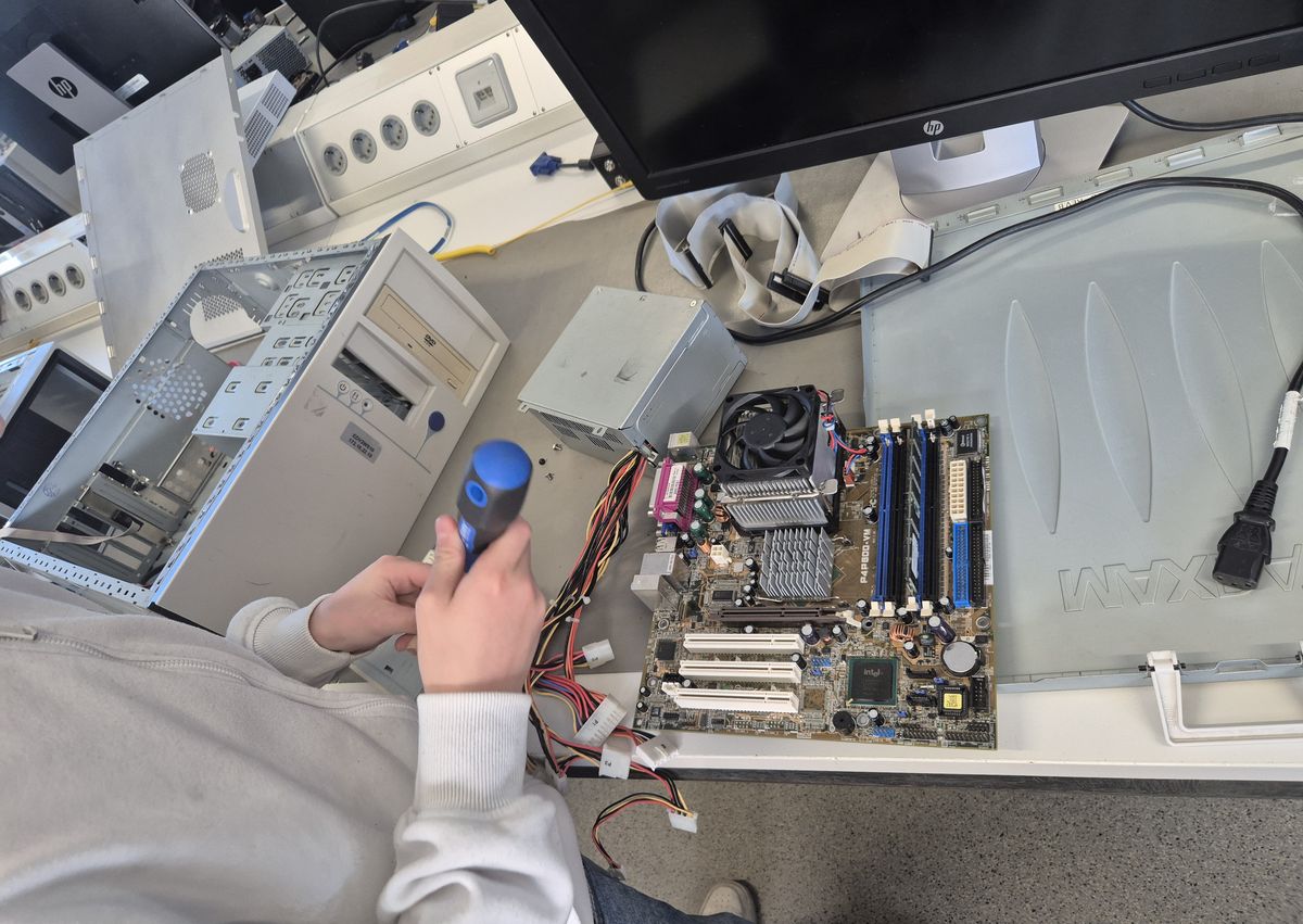 Schüler schraubt an einem Mainboard
