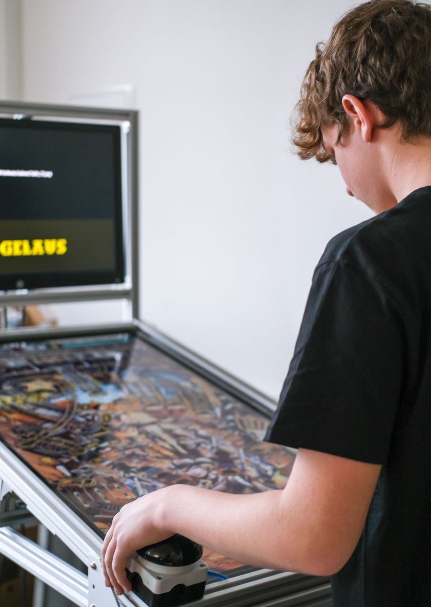 Schüler spielt an einem selbst entwickelten digitalen Flippertisch